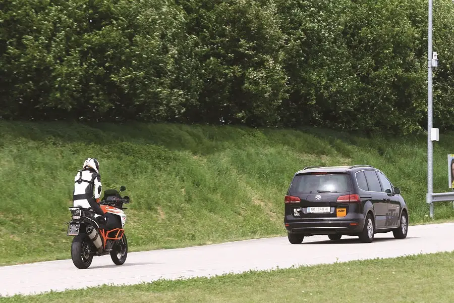 KTM 1290 Adventure following a car